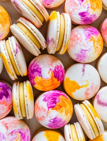 passionfruit macarons with a tie dye macaron shell filled with passionfruit ganache.