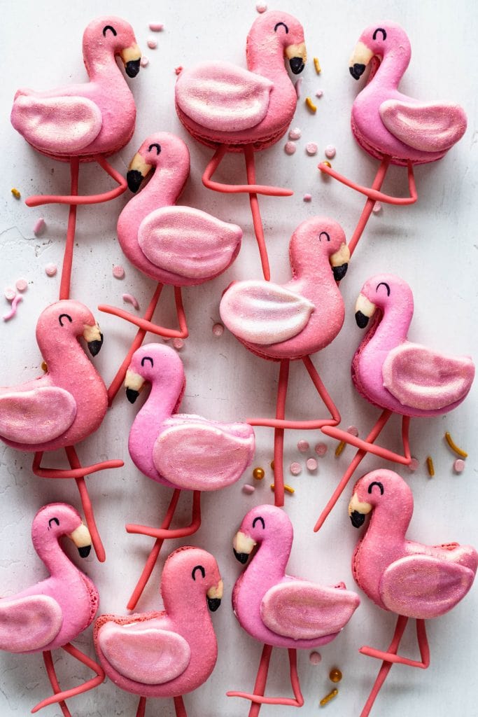 Flamingo Macarons with wings made out of chocolate and legs made out of fondant.