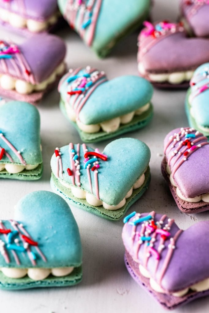 Heart Macarons filled with brownie, decorated with sprinkles and melted chocolate.