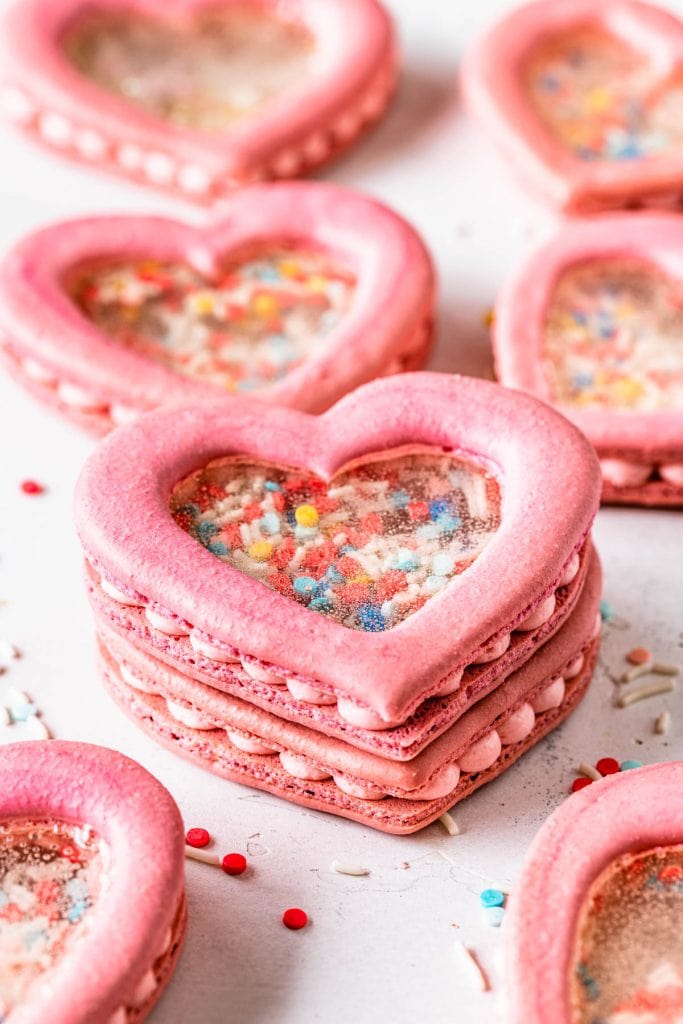 stacked heart shaker macarons filled with sprinkles and they have a transparent middle.