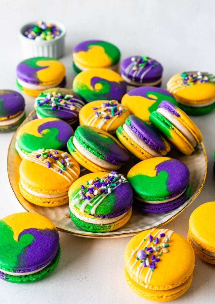Mardi Gras Macarons  with purple, yellow, green shells, topped with sprinkles.