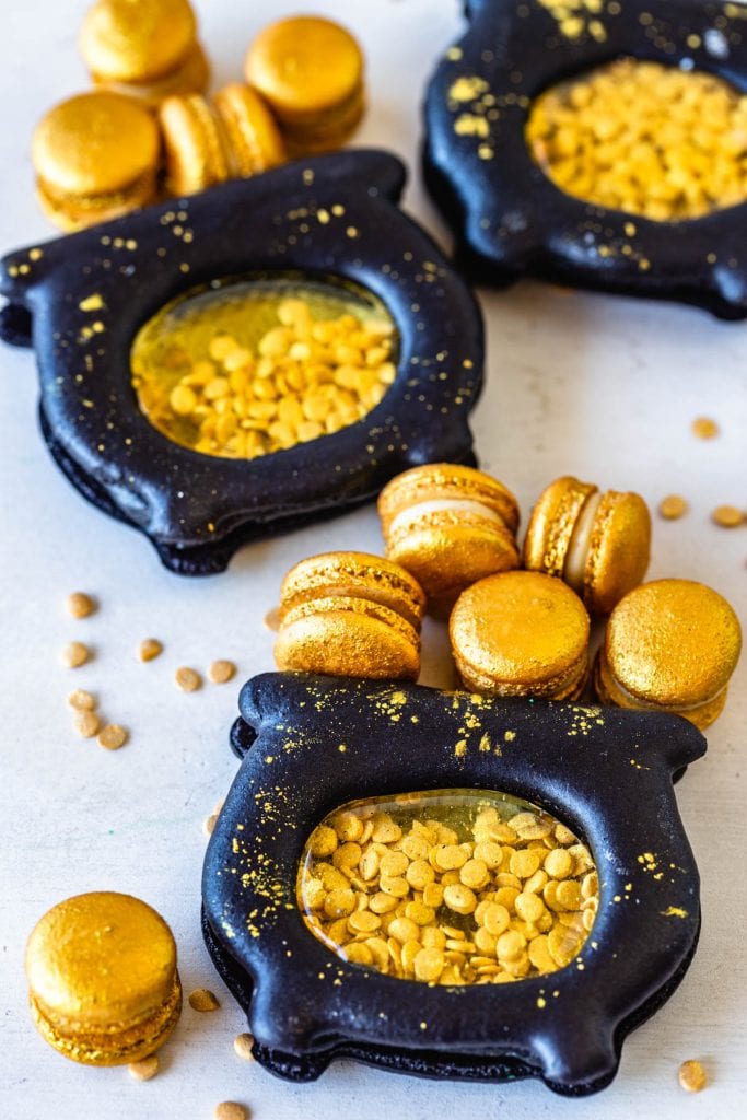 macarons shaped like pots of gold, filled with gold sprinkle coins, and with mini gold macarons.