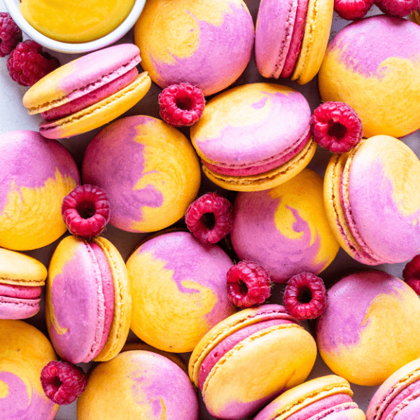 Mango Raspberry Macarons with bicolor shells pink and yellow.