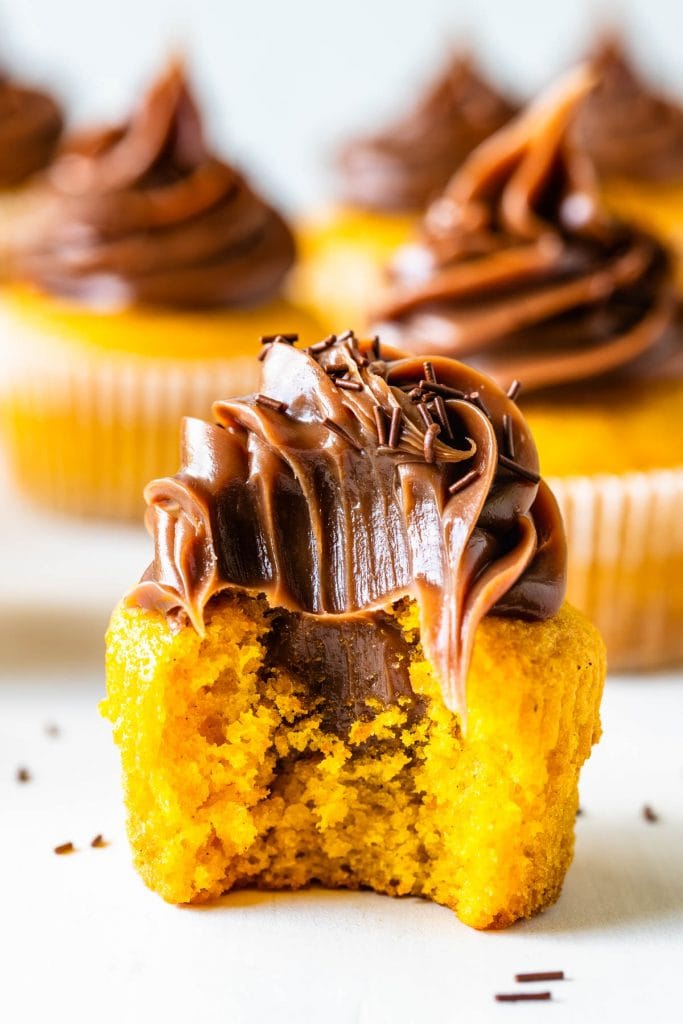 Carrot cupcakes topped with brigadeiro bit in half.