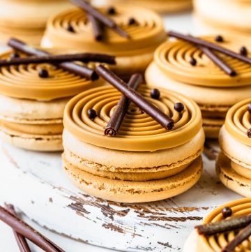 amarula macarons topped with a blonde chocolate swirl decoration and chocolate curls.