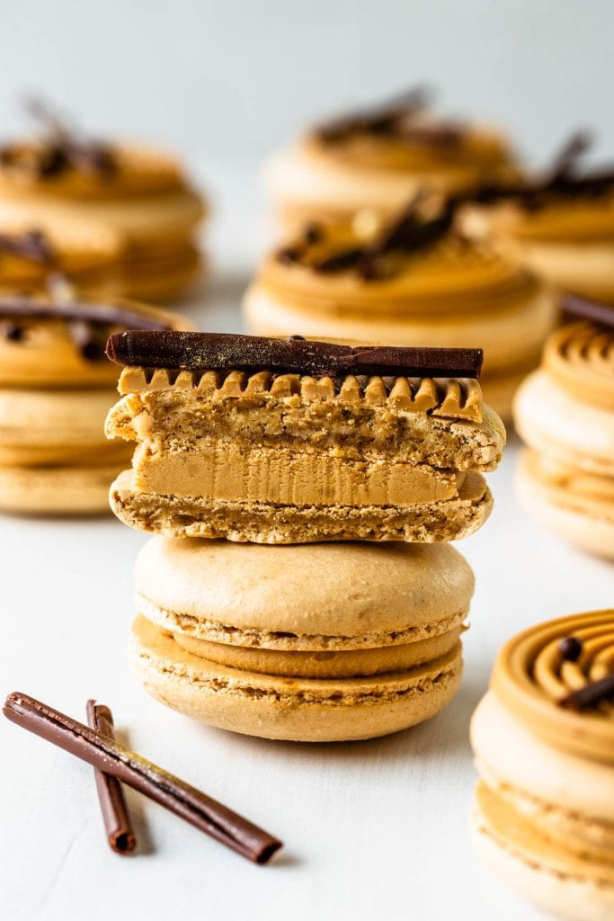 amarula macarons topped with a blonde chocolate swirl decoration and chocolate curls.