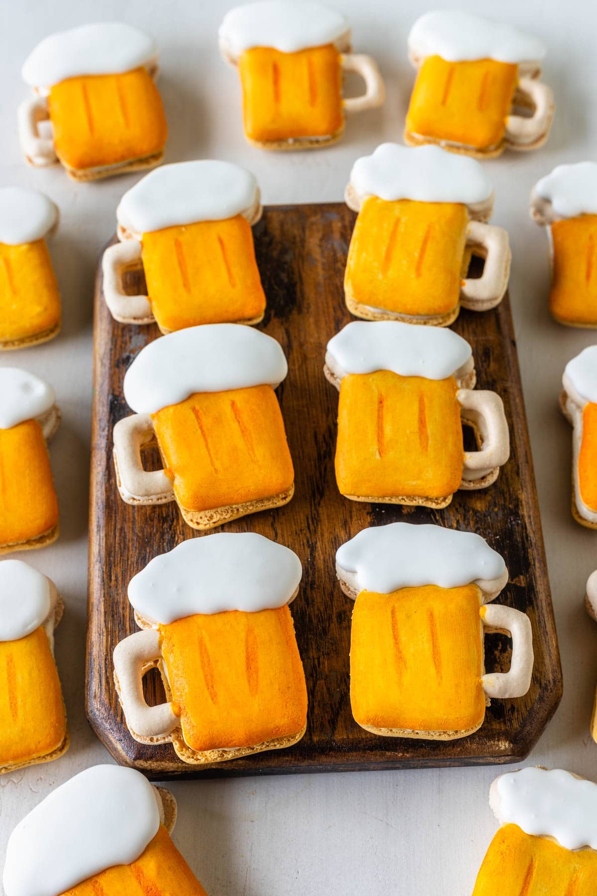 macarons shaped like beer on a wooden board.