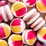 pink macarons with the shells painted with gold and pink, filled with ruby chocolate ganache.
