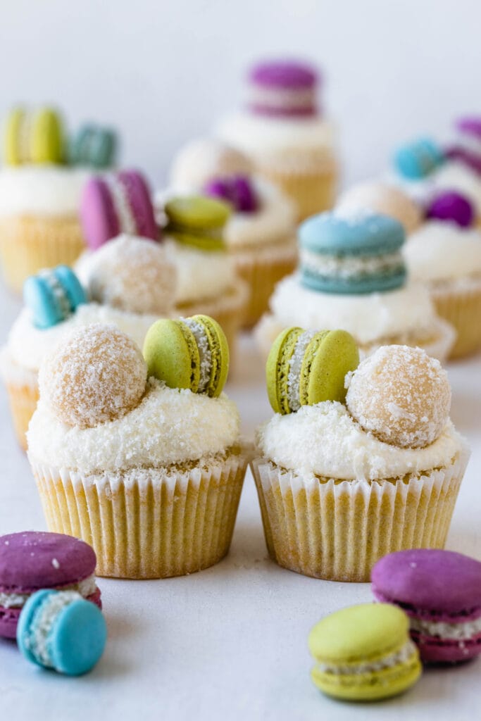 coconut cupcakes topped with macarons.
