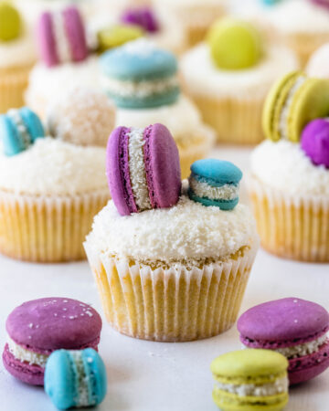 coconut cupcakes topped with macarons.