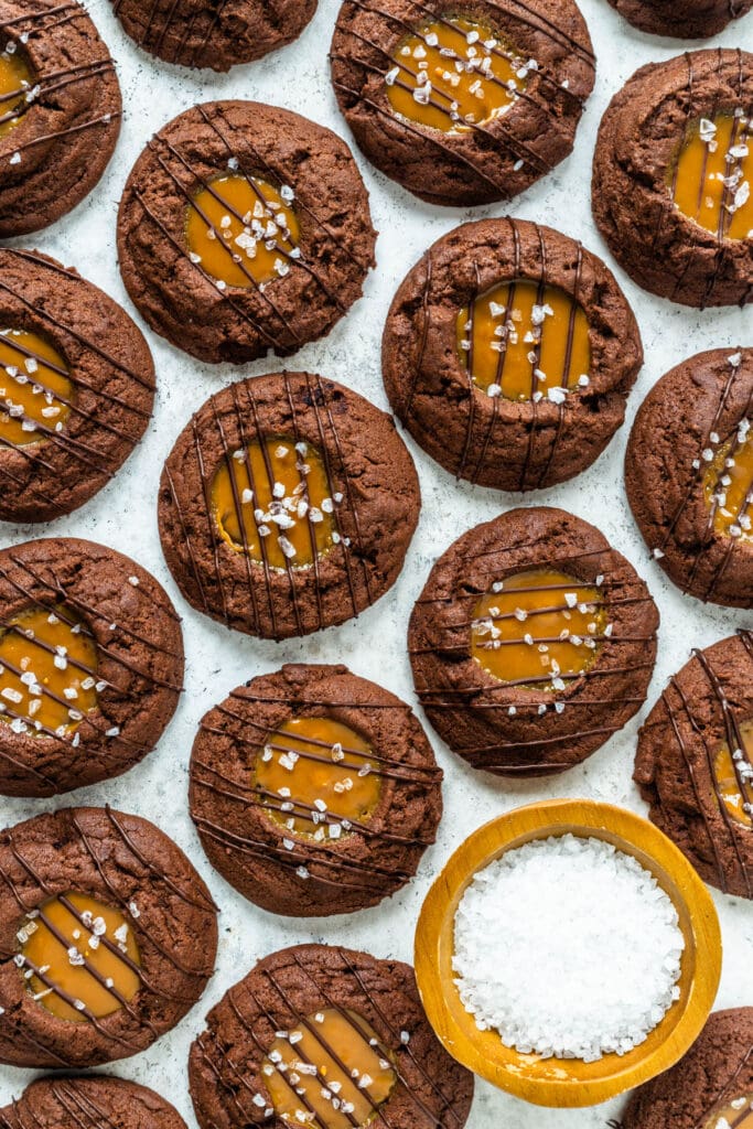 chocolate cookies with a dulce de leche center and salt sprinkled on top and a drizzle of chocolate.