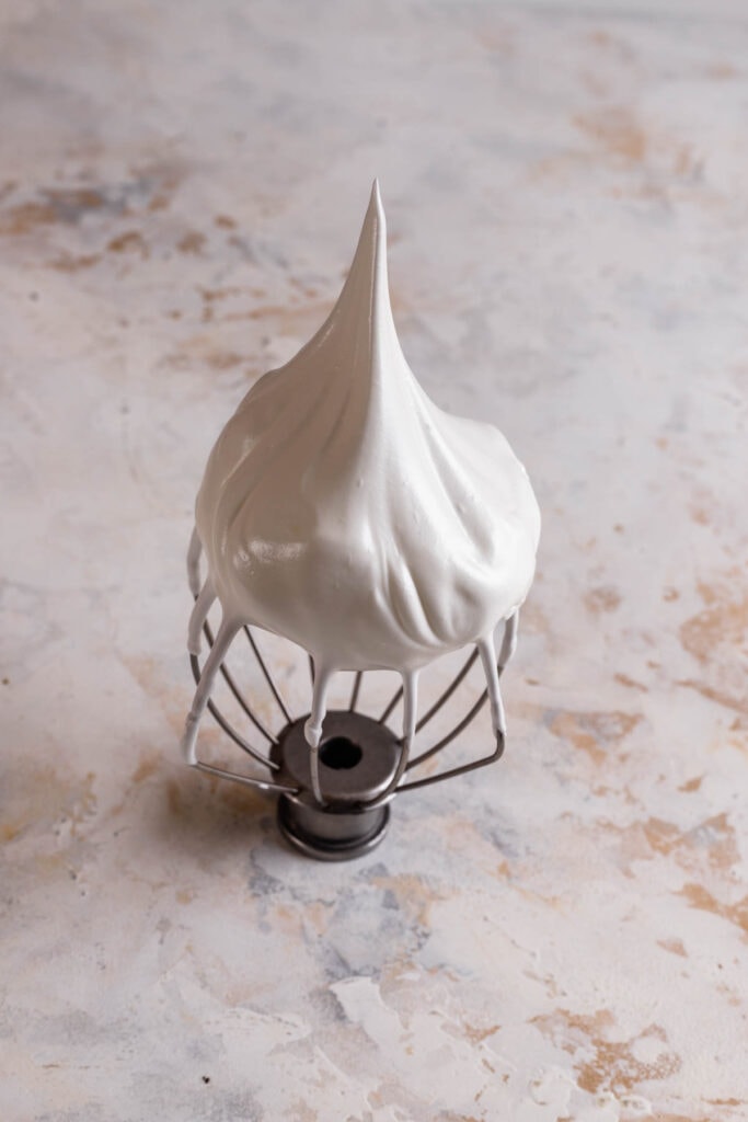 whipped meringue on a whisk.