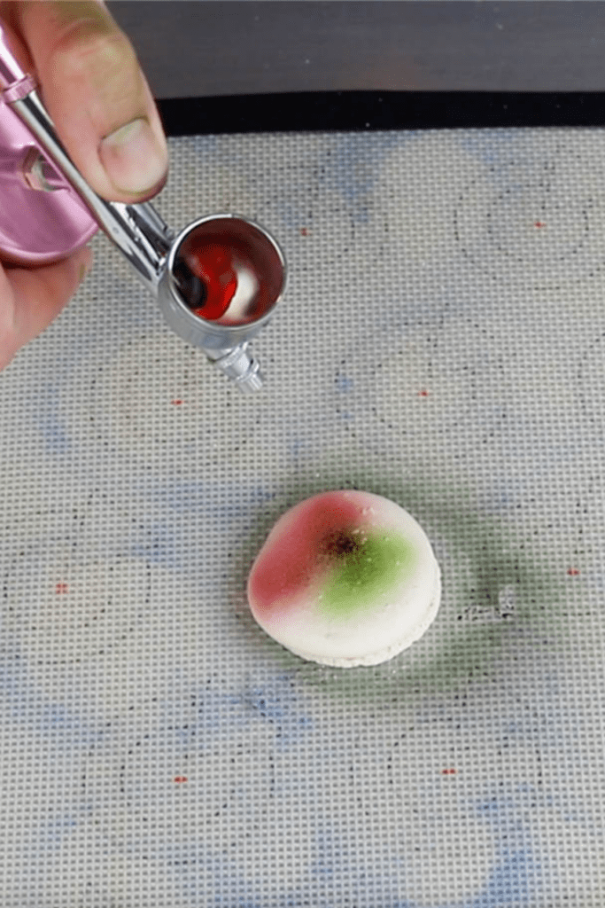 airbrushing macaron shell with food coloring.