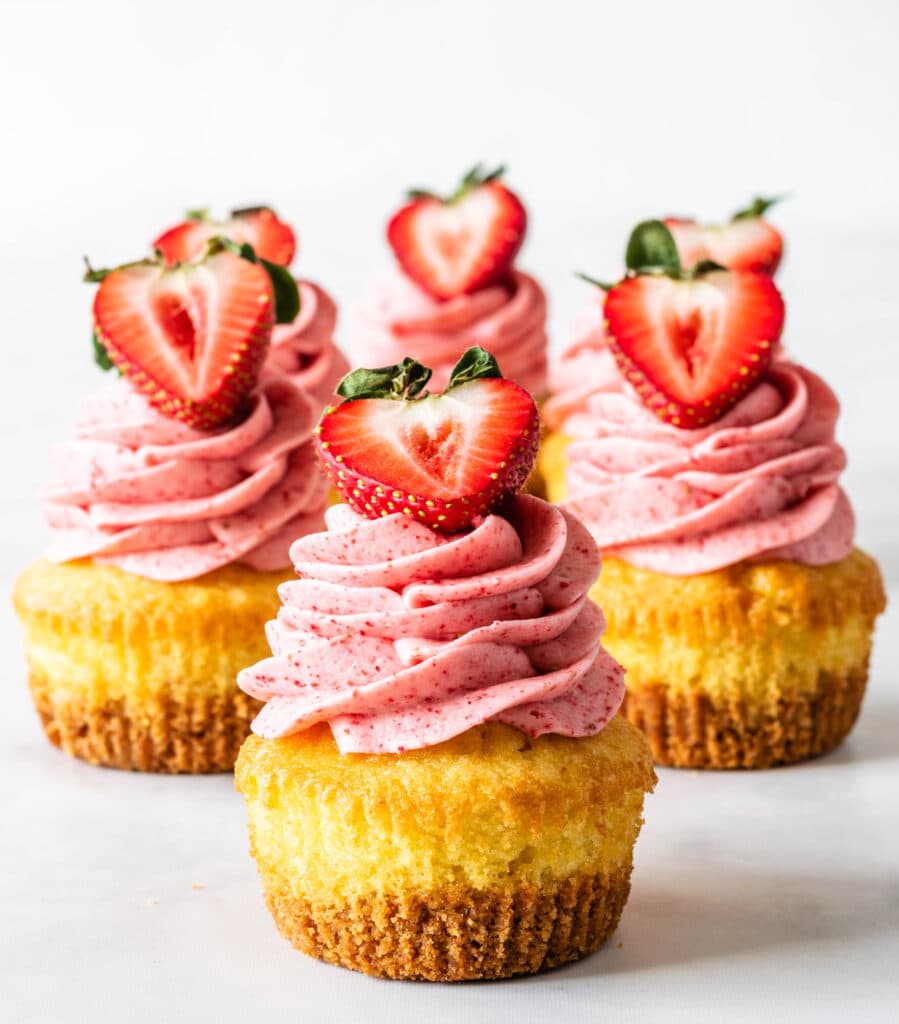 strawberry cheesecake cupcakes topped with fresh strawberries.
