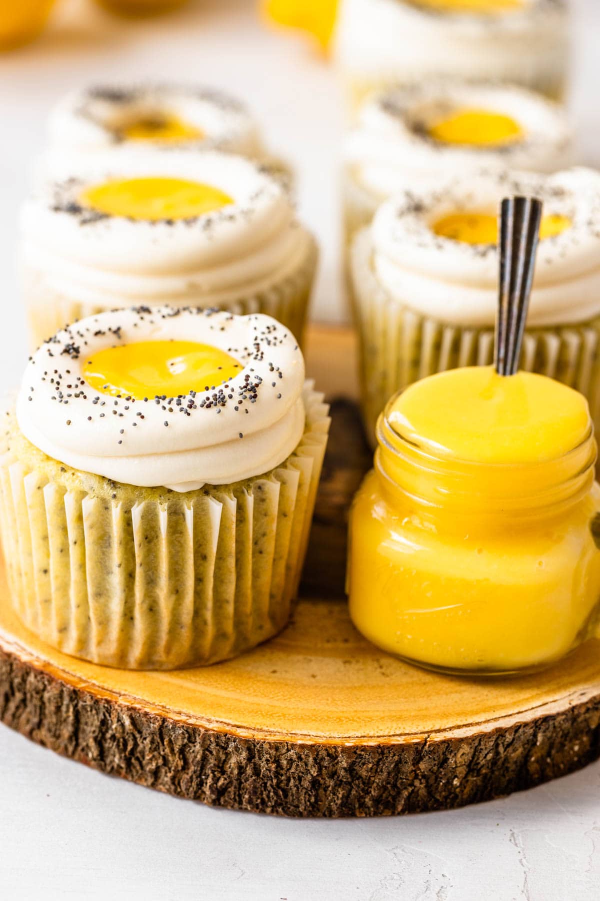 Lemon poppy seed cupcakes filled with lemon curd topped with cream cheese frosting and poppy seeds.