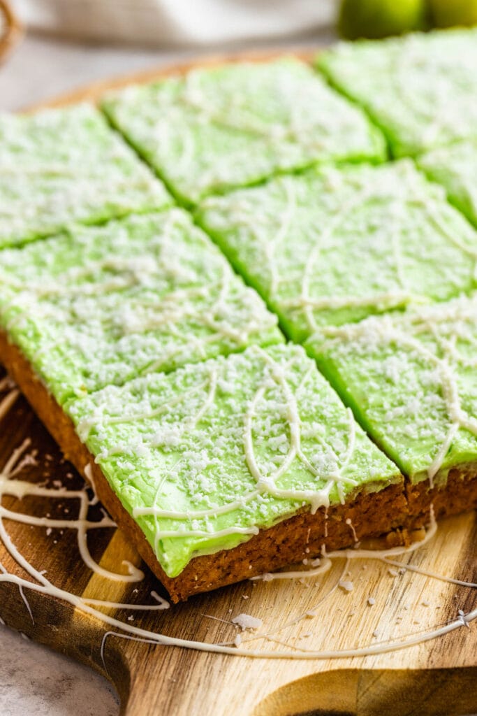 Lime frosted coconut bars topped with a green frosting.