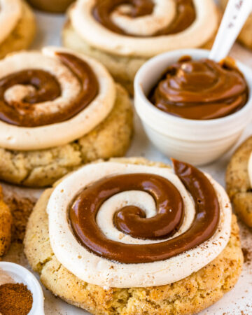 dulce de leche cookies with a swirl of dulce de leche and cream cheese frosting on top.