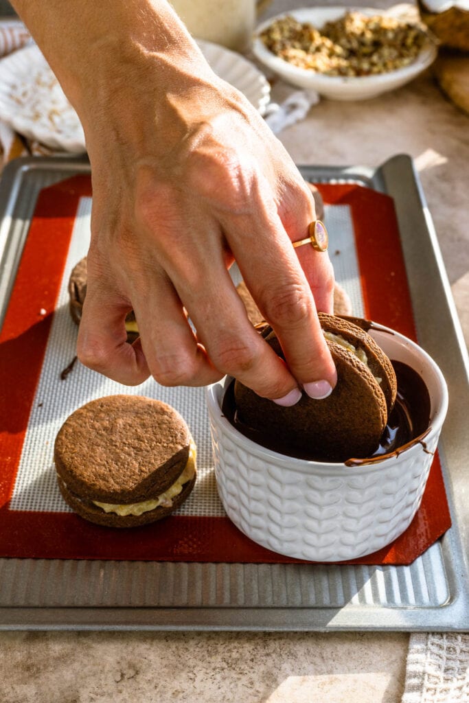 dipping cookie in melted chocolate.