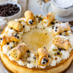 Cannoli cheesecake topped with mini cannoli.