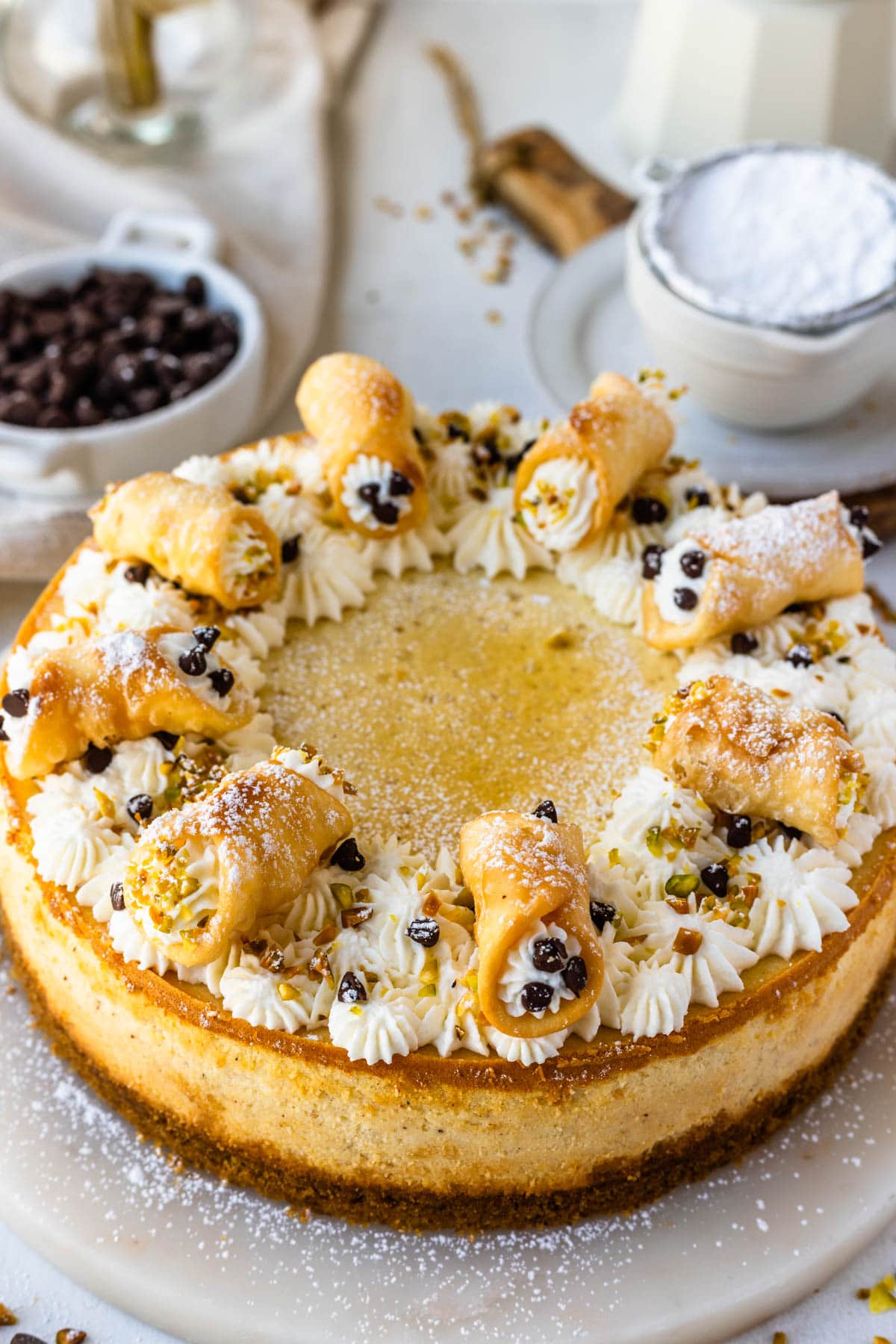 Cannoli cheesecake topped with mini cannoli.