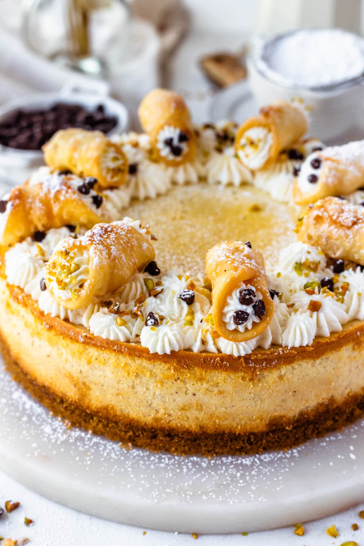 Cannoli cheesecake topped with mini cannoli.