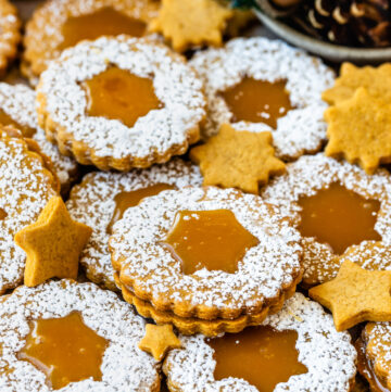 caramel gingerbread linzer cookies with a snow flake in the center.
