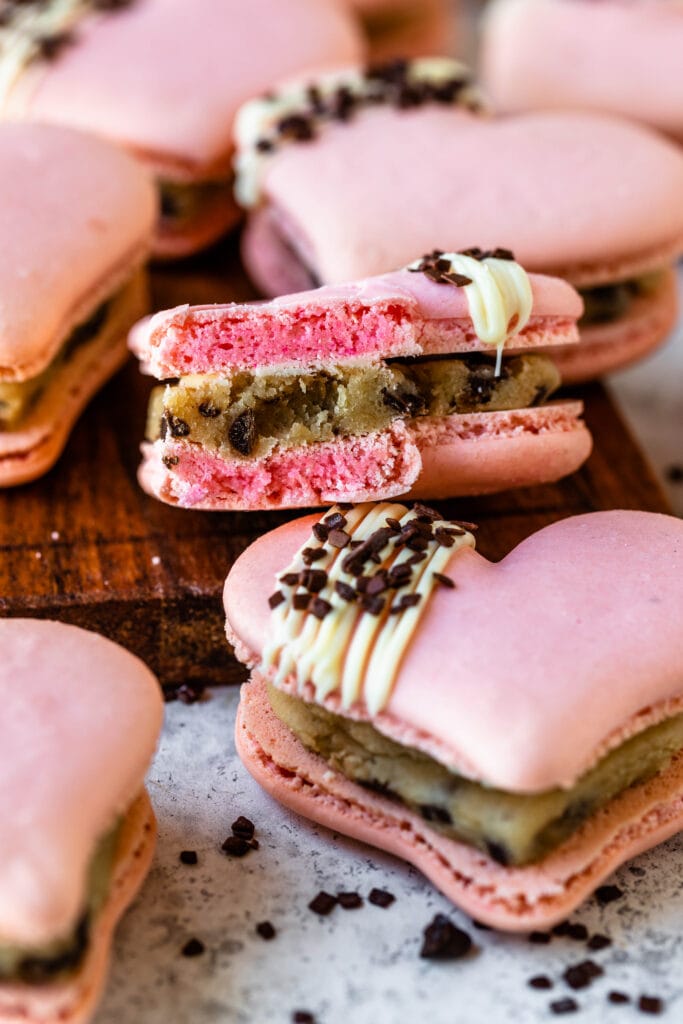 macaron shaped like a heart with a drizzled chocolate decoration on top.