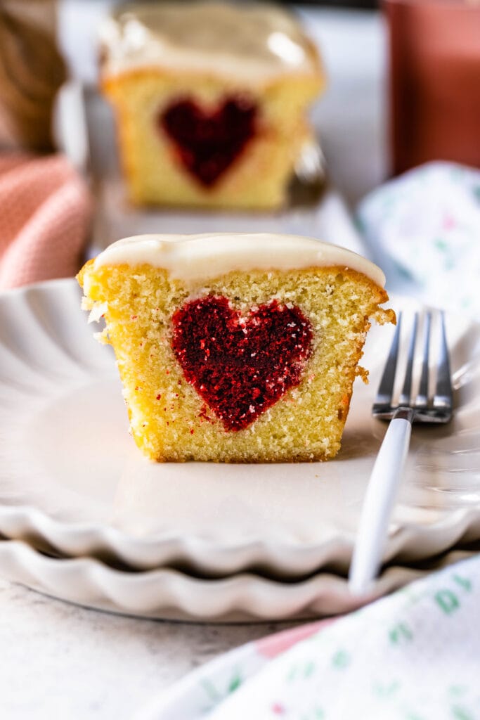 cake with heart inside sliced in half on a place with a fork.