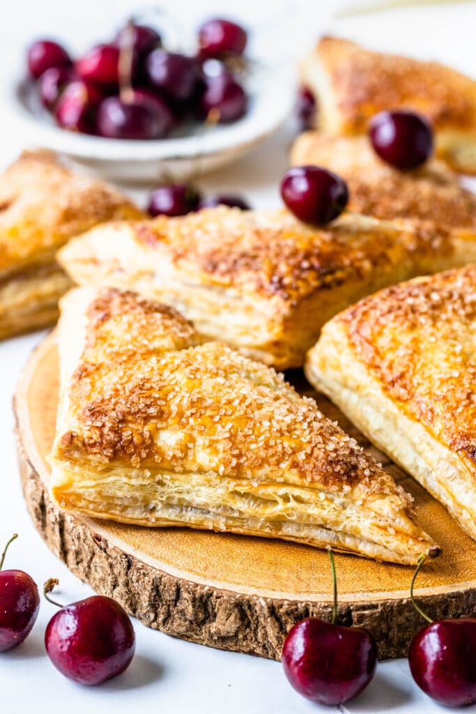 cherry turnovers without glaze on top of a board.