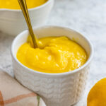 Lemon Curd in a bowl with a spoon.