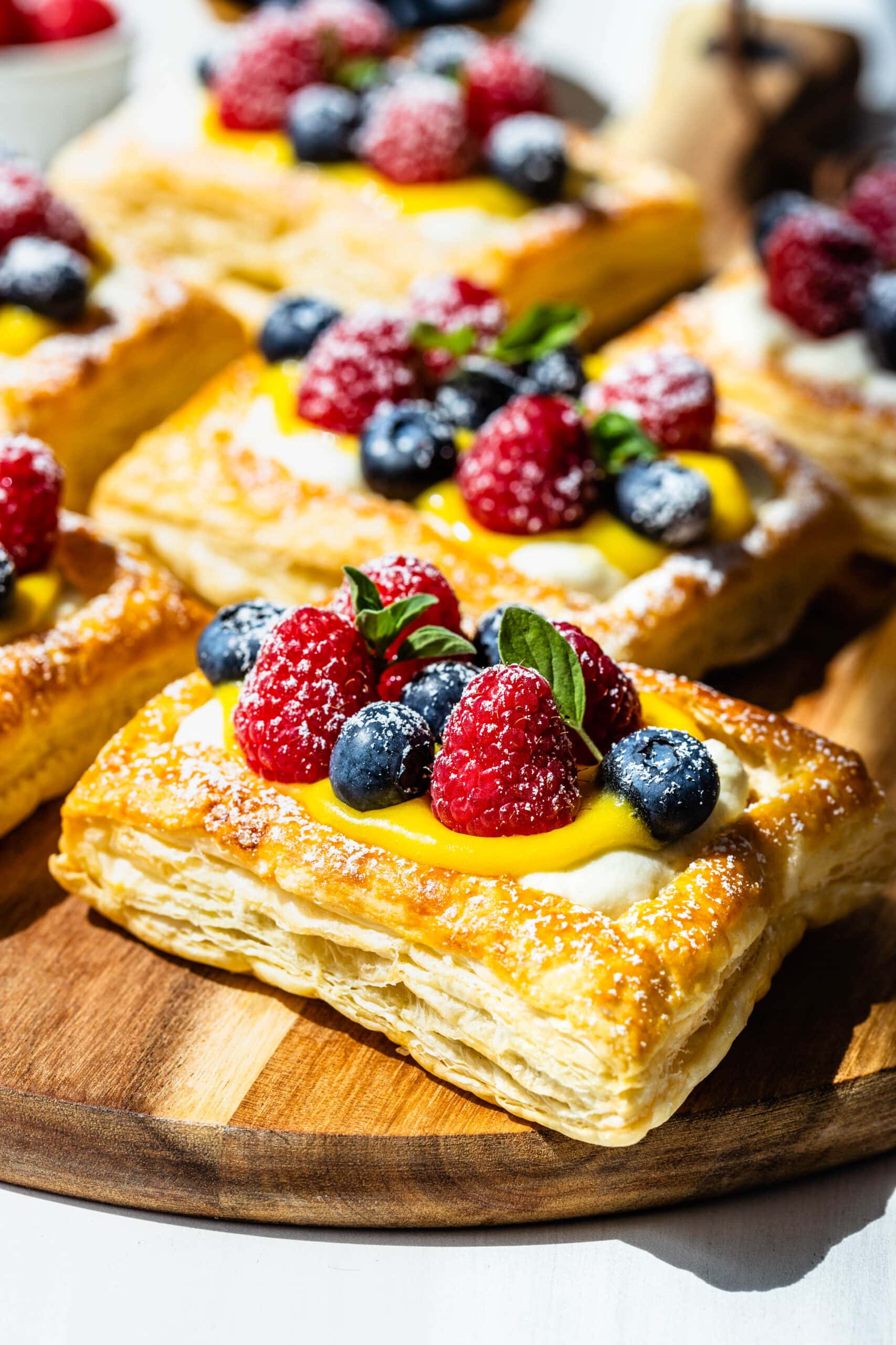 Puff pastry baked and filled with mascarpone cheese frosting and lemon curd, topped with berries.