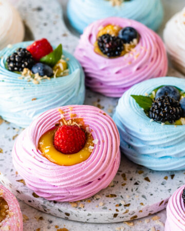 colorful pavlovas filled with lemon curd and topped with berries.