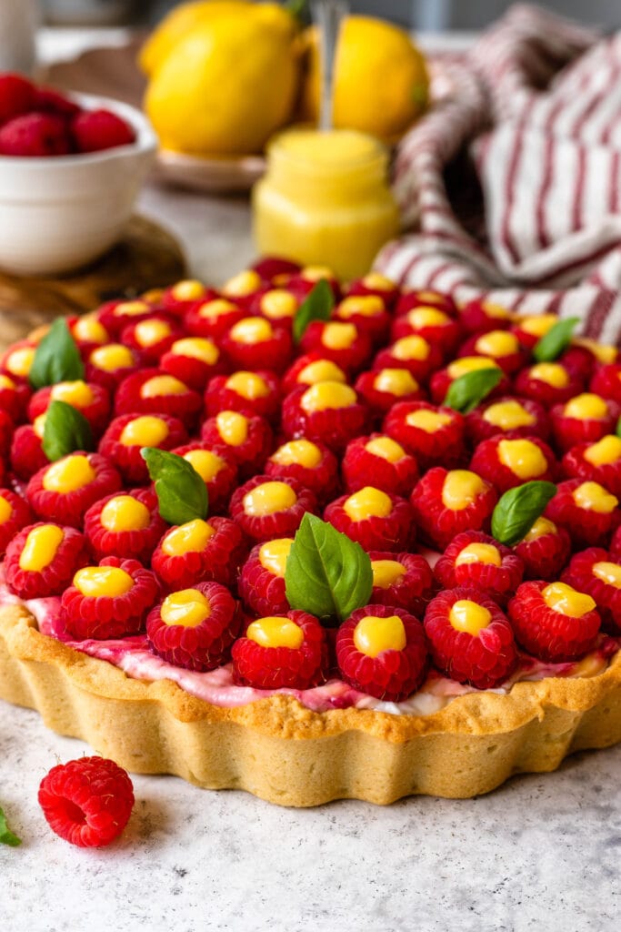 cheesecake pie topped with raspberries filled with lemon curd.