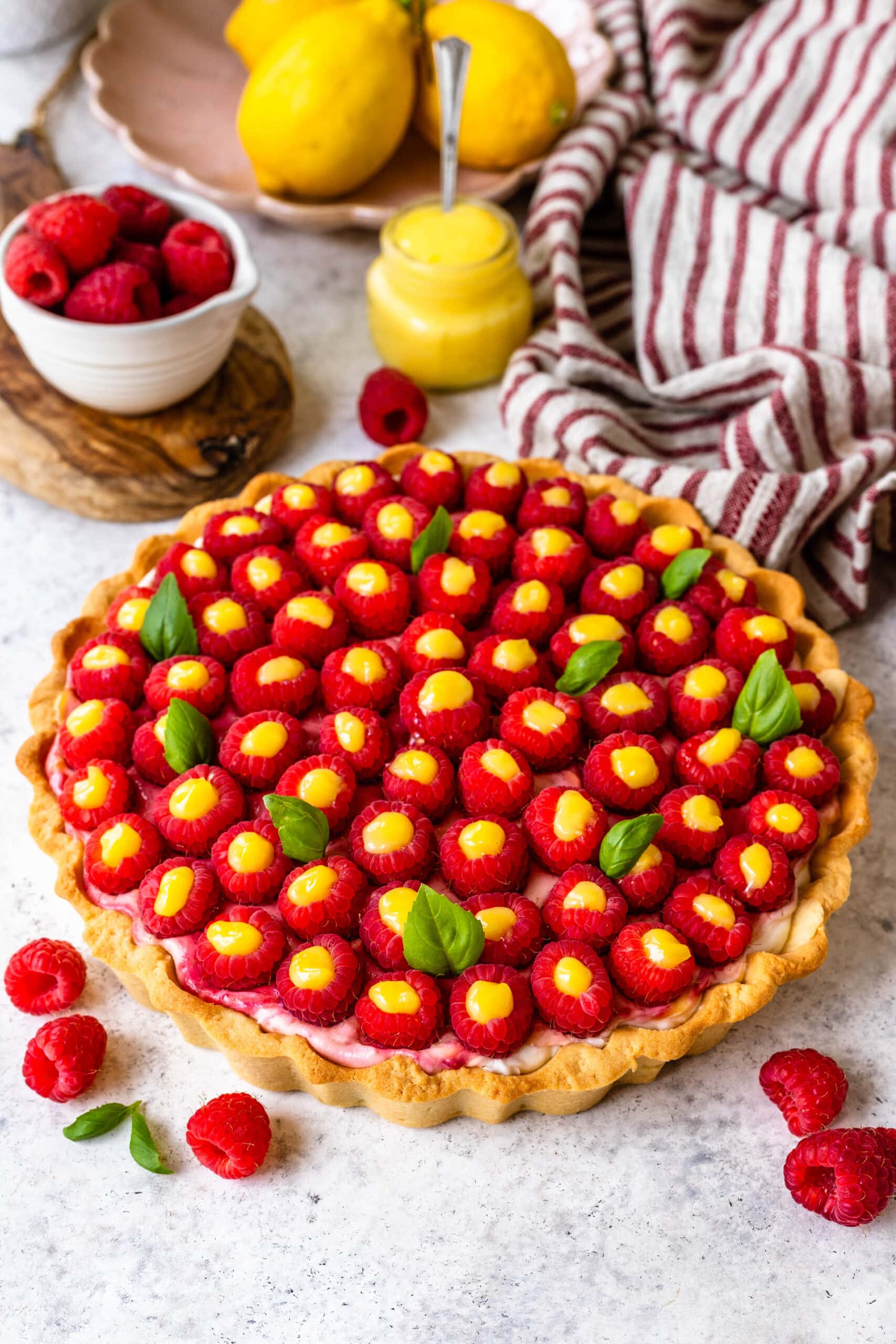 cheesecake pie topped with raspberries filled with lemon curd.