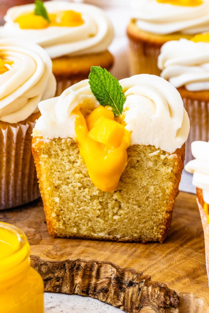 mango cupcakes sliced in half showing the center of the cupcakes with mango curd.
