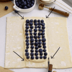 cutting 4 slits on the blueberry pastry to assemble it.