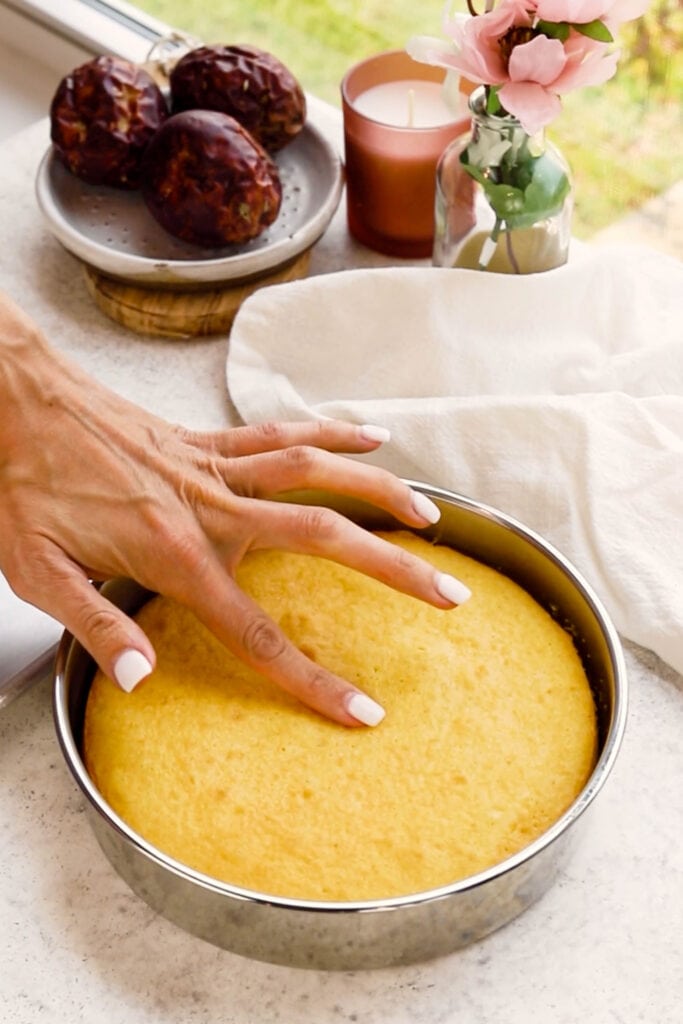 touching the top of the cake to test if it's done baking.