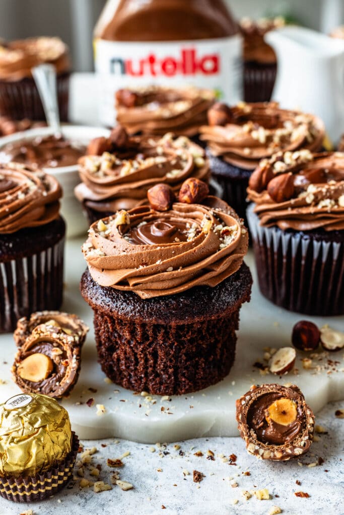 Nutella cupcakes with hazelnuts on top.