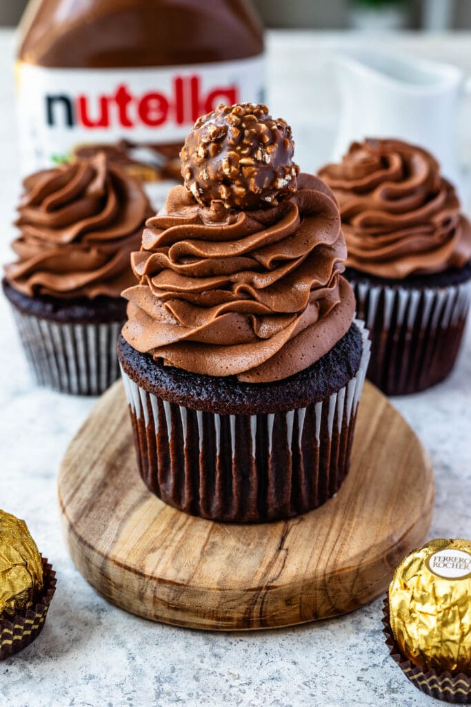 cupcakes frosted with nutella frosting, with a ferrero rocher on top.