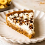 slice of vegan banoffee pie with whipped cream on top and chocolate shavings.