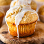 Vanilla muffins with vanilla glaze on top on a wooden board.