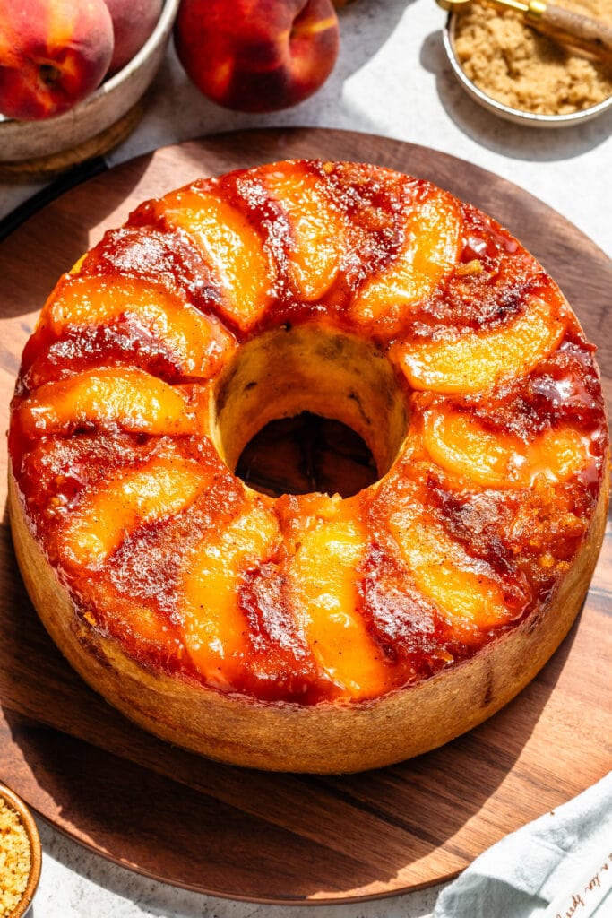 peach cobbler bundt cake with peaches and caramel on top.