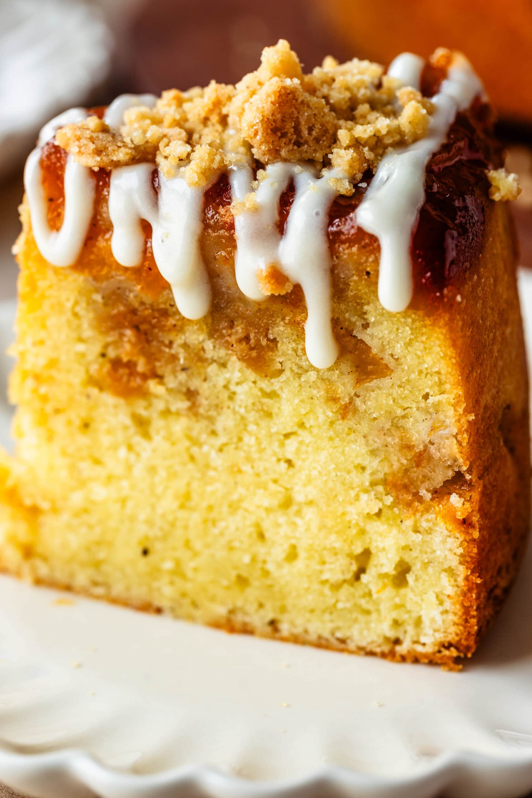 slice of peach bundt cake with glaze on top.
