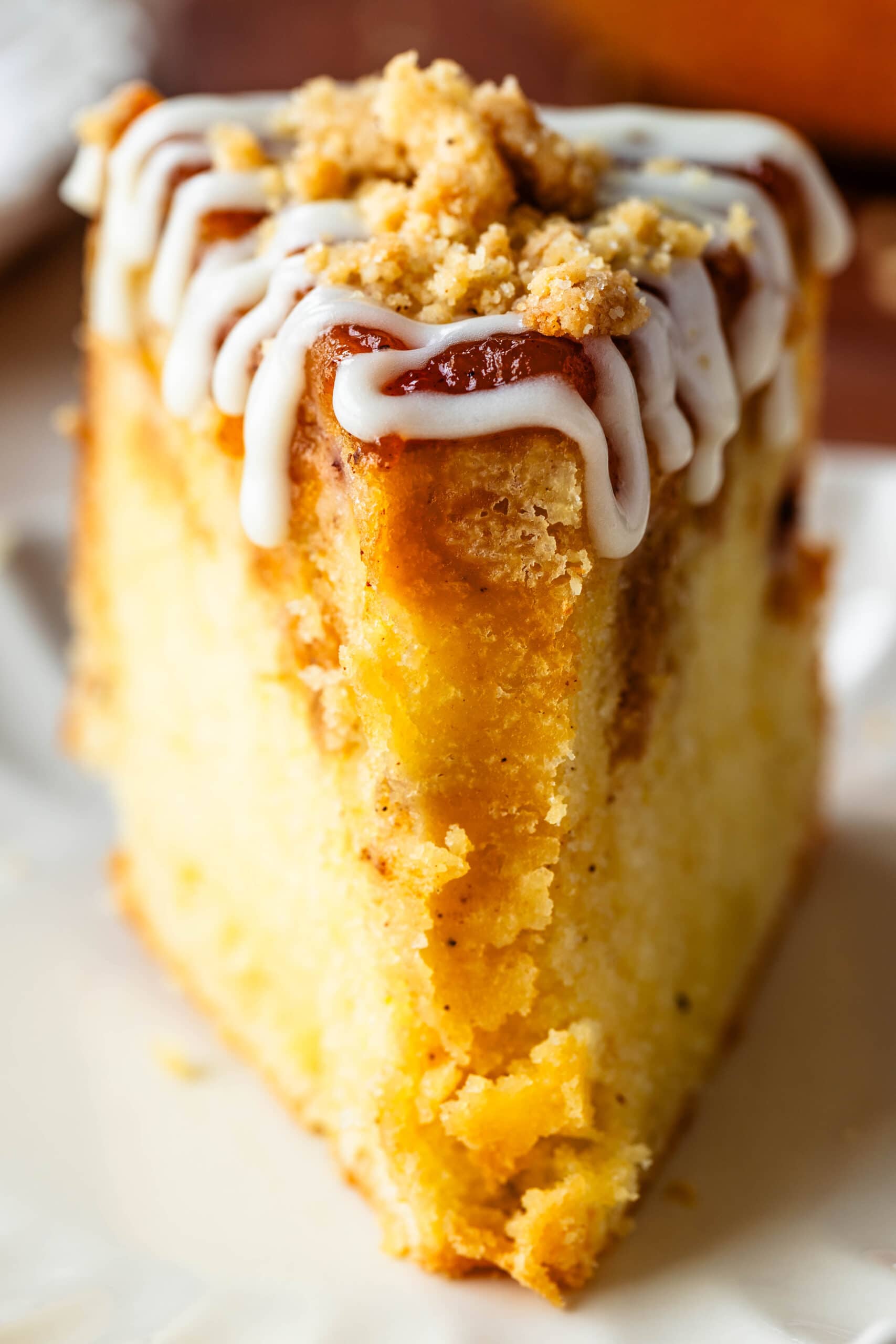 slice of peach cake with glaze on top.