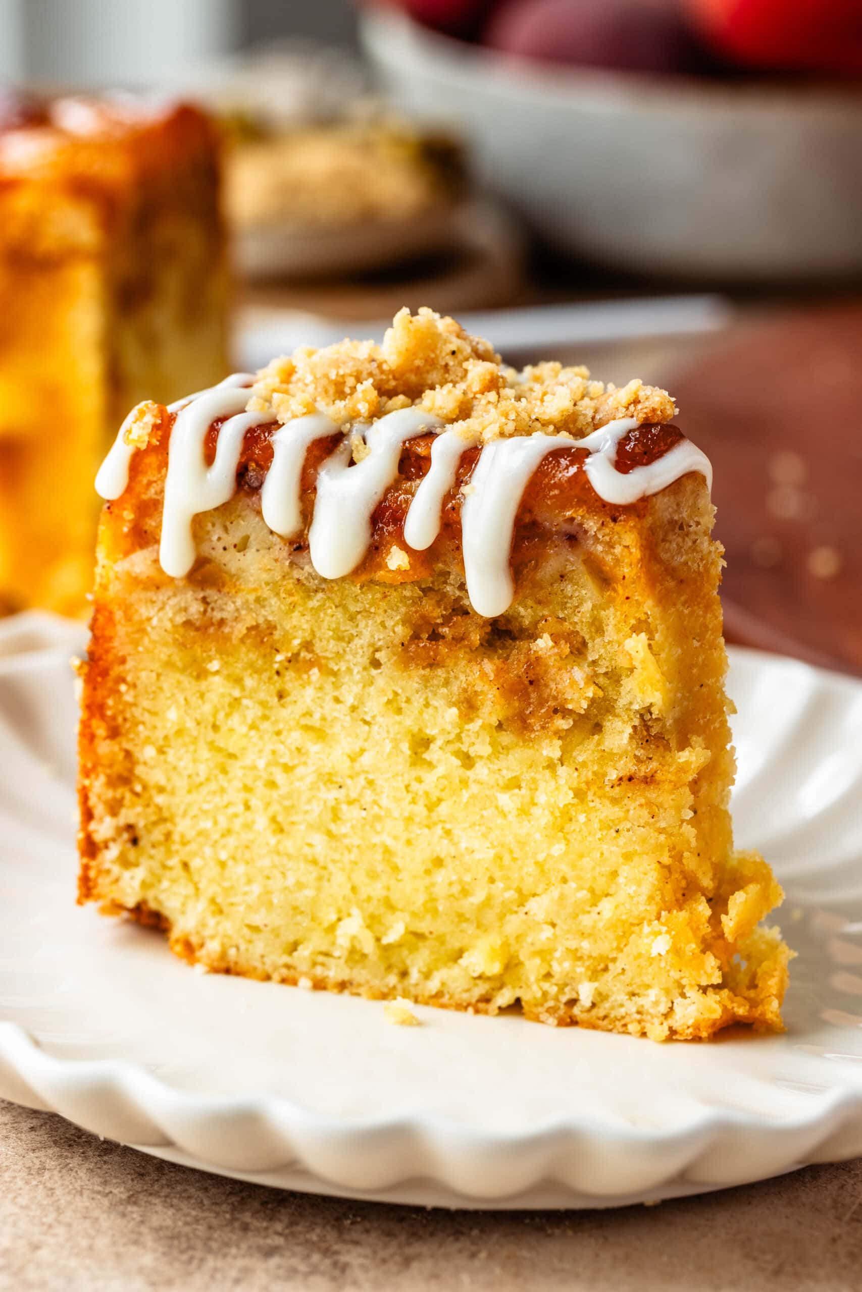 slice of peach cake with glaze on top.