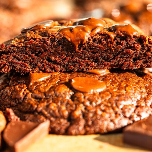 Brownie Cookies sliced in half on top of another cookie with chocolate around.