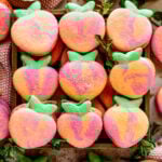 Macarons shaped like peaches in a box.