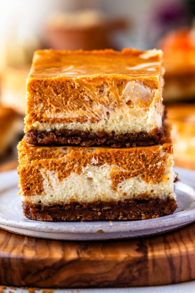 pumpkin cheesecake bars stacked on top of each other.