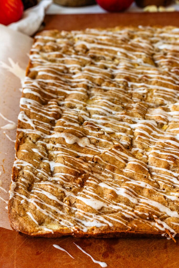 apple blondies baked on top of a board, with glaze on top.