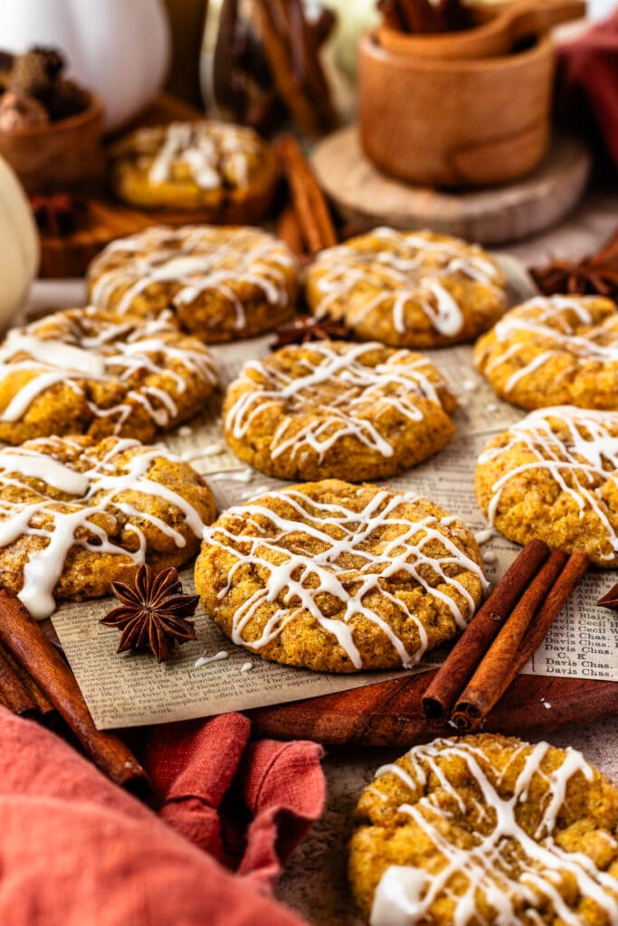 Pumpkin Cookies with glaze on top, cinnamon sticks around.